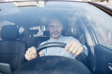 Lächelnder Geschäftsmann am Steuer eines Autos - JRFF02534