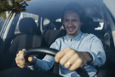 Smiling businessman driving car - JRFF02535