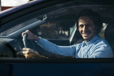 Portrait of smiling businessman driving car - JRFF02536