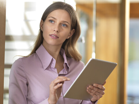 Geschäftsfrau benutzt Tablet im Büro, lizenzfreies Stockfoto