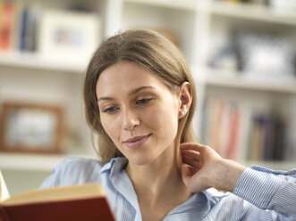 Young woman relaxing at home reading a book - ABRF00285