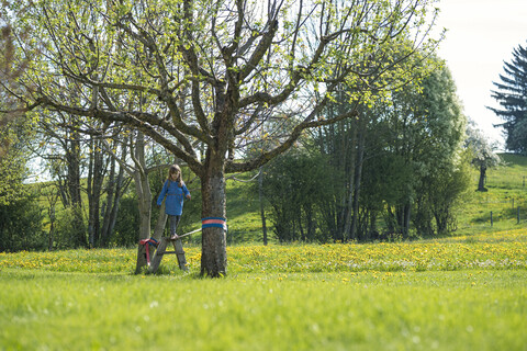 Girl balancing on a slackline in the countryside stock photo