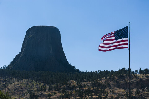 USA, Wyoming, US-Flagge vor dem Devils Tower National Monument, lizenzfreies Stockfoto