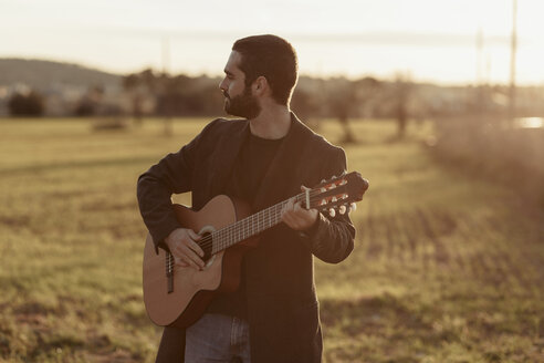 Male musician with beard playing the guitar in the countryside - LOTF00058