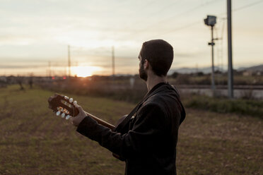 Unerkennbarer männlicher Musiker spielt bei Sonnenuntergang Gitarre - LOTF00061