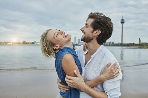 Germany, Duesseldorf, happy young couple at Rhine riverbank - RORF01668