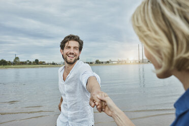 Germany, Duesseldorf, happy young couple at Rhine riverbank - RORF01671