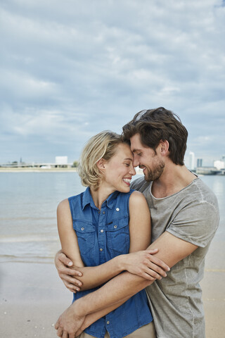 Happy young couple hugging at the riverbank stock photo