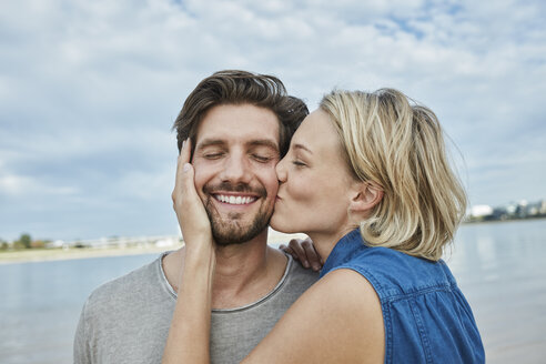 Happy young couple kissing on the beach - RORF01680