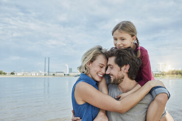 Deutschland, Düsseldorf, glückliche Familie mit Tochter umarmt am Rheinufer - RORF01701