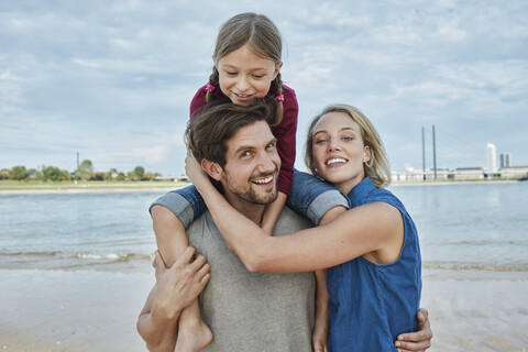 Deutschland, Düsseldorf, glückliche Familie mit Tochter am Rheinufer, lizenzfreies Stockfoto