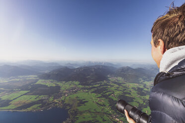 Mann mit Kamera schaut aus dem Heißluftballon - MMAF00813