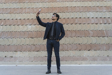 Modischer junger Geschäftsmann, der ein Selfie mit seinem Mobiltelefon macht - AFVF02333