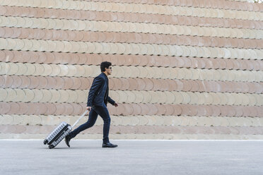 Running young businessman with rolling suitcase - AFVF02335