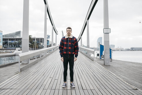 Young man wearing casual clothes standing on a harbor bridge - JRFF02550