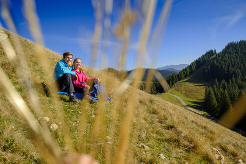 Deutschland, Bayern, Hörnle bei Bad Kohlgrub, glückliches junges Paar bei einer Pause auf einer Wiese in alpiner Landschaft - LBF02345