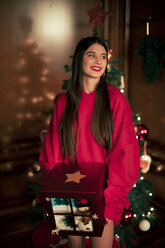 Portrait of smiling teenage girl with Christmas present - ACPF00423