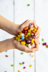 Colourful sweet jellybeans in hands, forming a heart - SARF04083