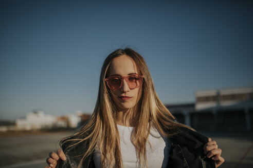 Porträt einer jungen Frau mit Sonnenbrille im Freien - DMGF00002