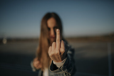 Close-up of young woman outdoors giving the finger - DMGF00029