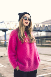 Portrait of fashionable young woman wearing sunglasses, cap and pink knit pullover - ACPF00428