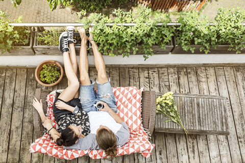 Young couple relaxing on their balcony in summer, drinking coffee stock photo