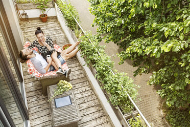 Verliebtes Paar, das im Sommer auf dem Balkon sitzt und sich unterhält - PESF01184
