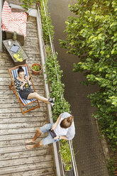 Junges Paar entspannt sich im Sommer auf ihrem Balkon - PESF01189
