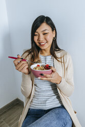Young woman eating fruit granola - KIJF02264