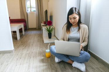 Young woman sitting on floor, using laptop - KIJF02269