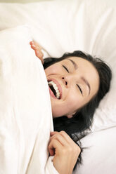 Beautiful woman lying in bed, smiling, portarit - PESF01197