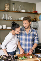 Young couple preparing food together, tasting spaghetti - PESF01233