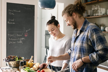 Young couple preparing food together, tasting spaghetti - PESF01239