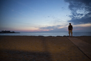 Italien, Sizilien, Isola delle Correnti, Lido Scialai, Mann steht am Strand in der Abenddämmerung - MAMF00382