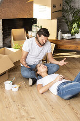 Couple with cardboard boxes in new home having a break - ERRF00740