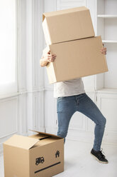 Unrecognizable man carrying cardboard boxes in new home - ERRF00756