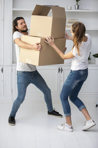 Ehepaar mit Freundin trägt Kartons in die neue Wohnung, lizenzfreies Stockfoto