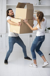 Ehepaar mit Freundin trägt Kartons in die neue Wohnung - ERRF00757