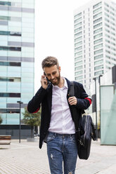 Stilvoller Geschäftsmann, der in der Stadt mit seinem Handy telefoniert - JRFF02584