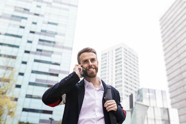 Stilvoller Geschäftsmann, der in der Stadt mit seinem Handy telefoniert - JRFF02585