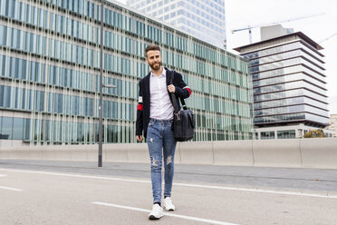 Stylish businessman walking in the city crossing a street - JRFF02601