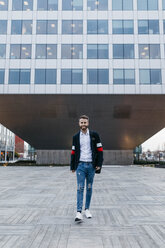 Portrait of stylish businessman walking in the city - JRFF02611