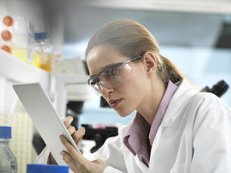 Scientist adding data to a tablet during an experiment in the laboratory - ABRF00300