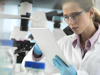 Scientist adding data to a tablet during an experiment in the laboratory - ABRF00301