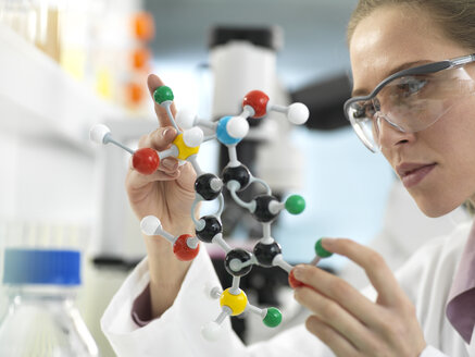Wissenschaftler, der im Labor anhand eines molekularen Modells einen Entwurf für eine Arzneimittelformel untersucht - ABRF00303