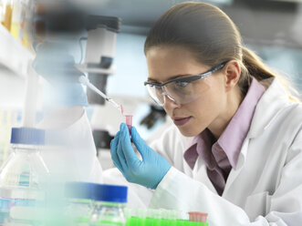 Scientist pipetting sample into a vial ready for automated analysis in the laboratory - ABRF00312