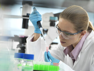 Scientist pipetting sample into a vial ready for automated analysis in the laboratory - ABRF00313