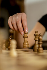 Nahaufnahme der Hand einer Frau, die eine Schachfigur bewegt - ACPF00438
