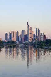 Deutschland, Frankfurt am Main, Skyline bei Sonnenaufgang mit Main im Vordergrund - RUEF02102