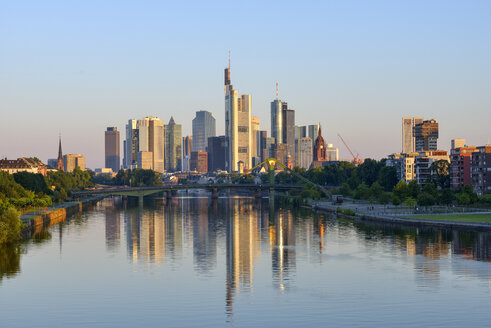 Deutschland, Frankfurt am Main, Skyline bei Sonnenaufgang mit Main im Vordergrund - RUEF02103